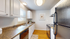 Bright, modern kitchen with sleek black appliances, white cabinetry, and warm wood flooring, perfect for culinary creativity.