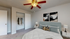 Cozy bedroom boasting a plush bed, stylish ceiling fan, and spacious closet with modern wall art.