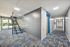 Well-lit interior hallway with modern staircase and blue accent doors at Flats on 70th at Midtown in Westminster, CO
