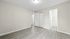 Bright and airy bedroom with sleek wood flooring, ample closet space, and a stylish white interior.