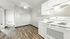 Bright and inviting kitchen with sleek white cabinetry, modern appliances, and elegant wood flooring.