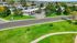 Aerial view of a charming apartment complex nestled among lush greenery, with a scenic road and vibrant community setting.