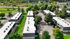 Aerial view of modern apartment complex surrounded by lush greenery and scenic pathways, ideal for tranquil living.
