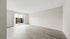 Bright, spacious living area with elegant hardwood floors and large sliding glass doors leading to a private patio.