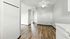 Bright and modern apartment featuring sleek wooden flooring and light gray walls, ideal for a contemporary living space.