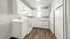Bright and airy modern kitchen featuring sleek white cabinets, stylish countertops, and elegant wood flooring.