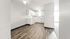 Bright and modern white kitchen with sleek cabinetry and elegant wood flooring.