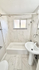 Elegant bathroom featuring a modern bathtub with sleek fixtures, a chic pedestal sink, and bright natural lighting.