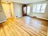 Bright and inviting living room with elegant hardwood floors, large window, and modern door creating a warm, welcoming atmosphere.
