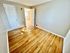 Bright and welcoming room with elegant wooden floors, large doors, and ample natural light.