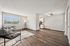 Bright and airy living room with modern seating, wooden flooring, and a cozy atmosphere adjacent to a compact kitchen.