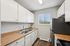 Modern kitchen with sleek stainless steel appliances, elegant wooden countertops, and ample cabinet storage complemented by bright natural light through the window.