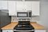Modern kitchen with sleek stainless steel appliances and stylish wooden countertops.