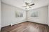Bright and airy bedroom with modern ceiling fan, large windows, and elegant wood flooring.