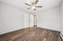 Bright room with elegant wood flooring, pristine white doors, and a modern ceiling fan, perfect for comfortable living.