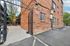 Charming brick apartment exterior with gated entrance and a serene courtyard view.