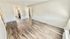 Bright, spacious living area with sleek wooden floors and ample natural light, creating an inviting atmosphere.