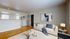 Cozy living room with elegant wooden flooring, modern art decor, and plush furniture, highlighting a bright, inviting space.