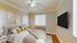 Elegant bedroom featuring a cozy bed with plush pillows, stylish wall art, a ceiling fan, and a mounted flat-screen TV for a modern lifestyle.