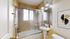 Elegant bathroom with modern fixtures, glass-enclosed tub, and artistic decor.