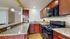 Elegant kitchen with granite countertops, cherry wood cabinets, and modern appliances, perfect for culinary enthusiasts.