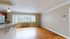 Bright and spacious living area with polished hardwood floors and a stylish breakfast bar, perfect for entertaining.