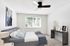 Spacious bedroom with ceiling fan, large window, and plush carpeting at Flats on 70th at Midtown in Westminster, CO