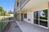 Private covered patio with sliding glass door and green space views at Flats on 70th at Midtown in Westminster, CO