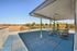 Covered rooftop terrace with outdoor dining, lawn games, and open views at Flats on 70th at Midtown in Westminster, CO
