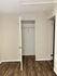 Bright room with sleek hardwood flooring and a spacious closet, perfect for modern living.