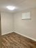 Cozy apartment room with elegant wood flooring and soft neutral walls, illuminated by modern lighting.