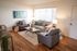Bright and welcoming living room with modern furniture, hardwood floors, and large window for natural light.