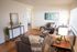 Bright and inviting living room with modern furnishings, featuring cozy sofas, stylish decor, and abundant natural light.