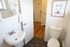 Bright and modern bathroom featuring a sleek white sink, contemporary fixtures, and a stylish artwork accent.