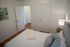Cozy bedroom with wooden floors, stylish artwork, and ambient lighting for a relaxed atmosphere.