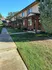 Charming townhouse exterior with a lush green landscape, perfect for serene living.