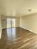 Spacious living room with wooden floors and large sliding glass doors opening to a patio.