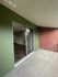 Inviting patio area with sliding glass doors and a combination of green and brick walls.