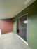 Inviting balcony with green walls and sliding glass door, perfect for relaxation.