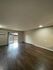 Inviting living area with large window, dark wood floors, and modern lighting.