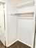 Bright and spacious walk-in closet with wooden flooring and a hanging rod.