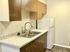 Sleek kitchen with modern cabinetry, dual sink, and refrigerator.