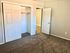 Spacious bedroom with plush carpet, open closet, and neutral walls for a welcoming feel.