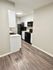 Sleek kitchen with modern appliances, wood flooring, and minimalistic design.