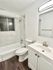 Elegant bathroom with modern fixtures, white vanity, and marble-tiled shower.