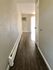 Bright and inviting apartment hallway with wood flooring and a wall-mounted air conditioner.