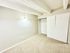 Bright and minimalist bedroom with neutral walls, plush carpeting, and built-in closet.