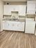 Compact modern kitchenette with white cabinetry, double sink, and integrated washer-dryer unit.