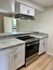 Modern kitchen with sleek cabinetry, granite countertops, and a stainless steel stove.