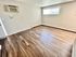 Bright and airy living room with modern wood flooring and large window.